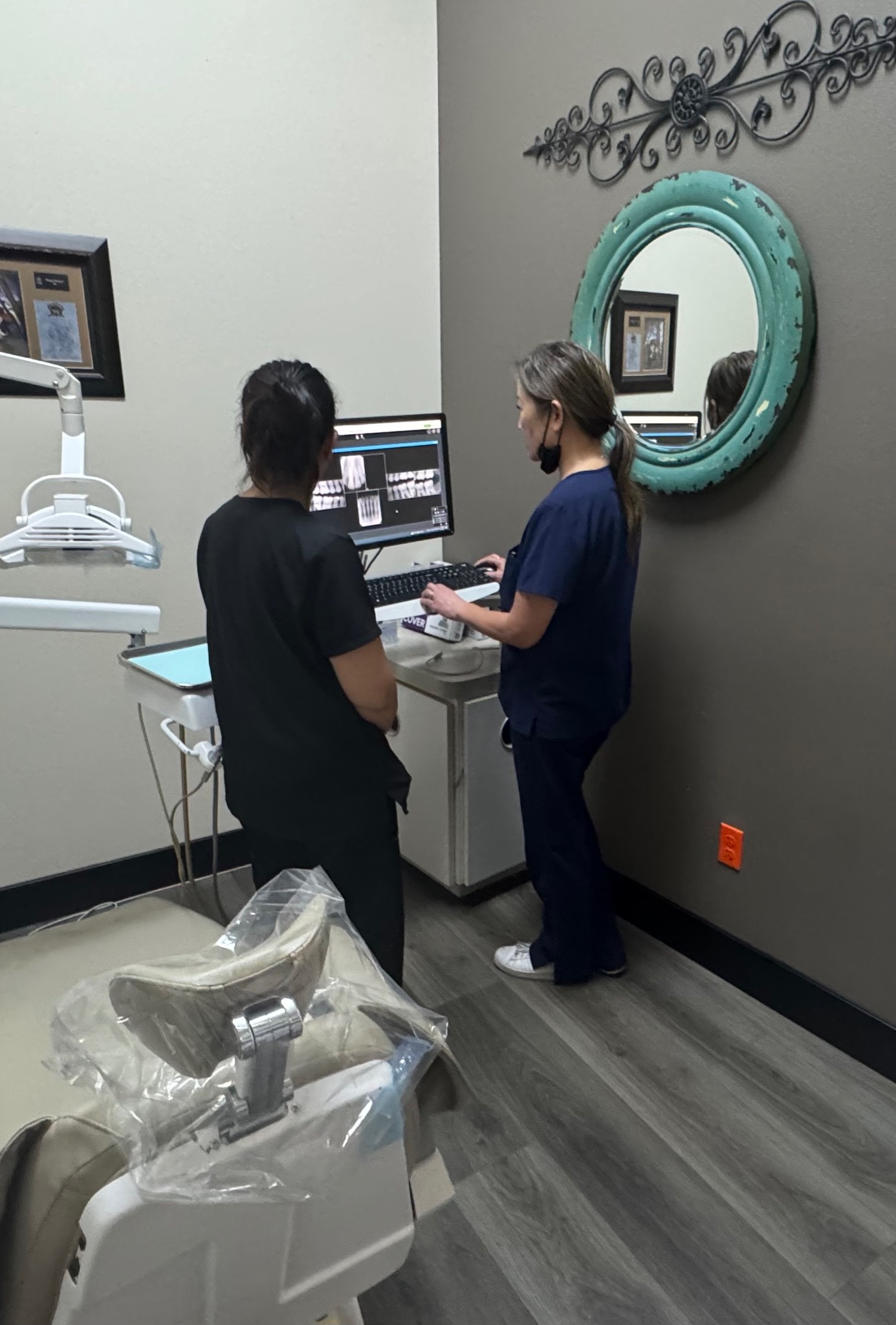 Two Moore Family Dentistry team members reviewing dental images in a treatment room